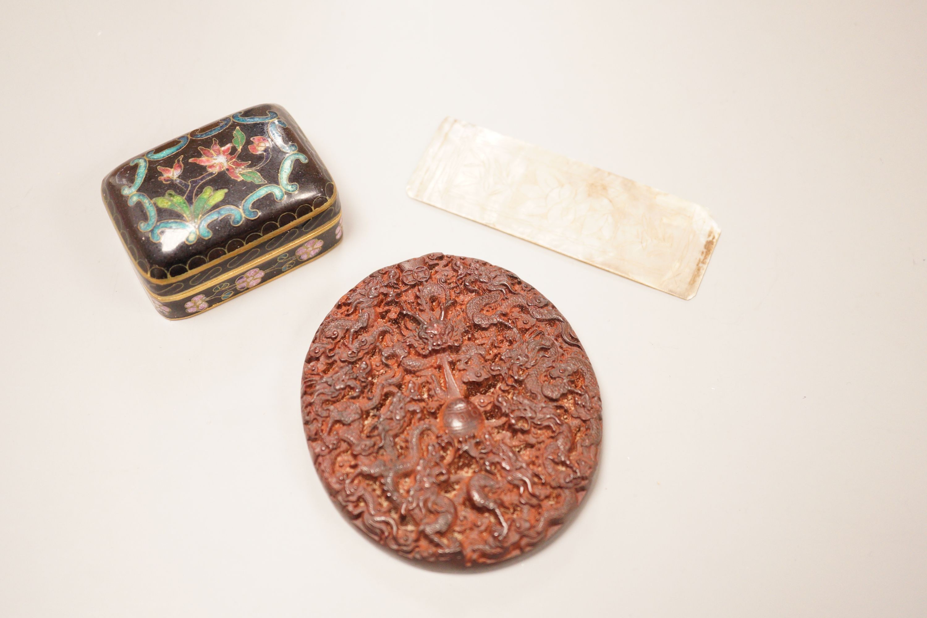 A Chinese cloisonne box, a lacquer carving and a mother of pearl counter